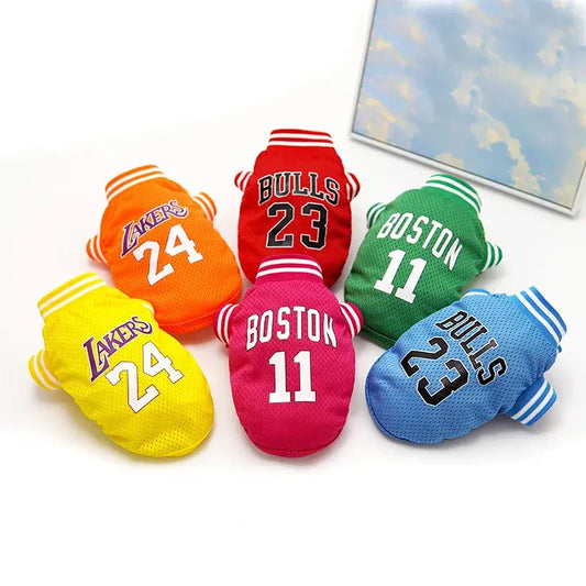 Collection of colorful pet basketball jerseys featuring team-inspired designs in yellow, red, green, blue, and pink for small pets.